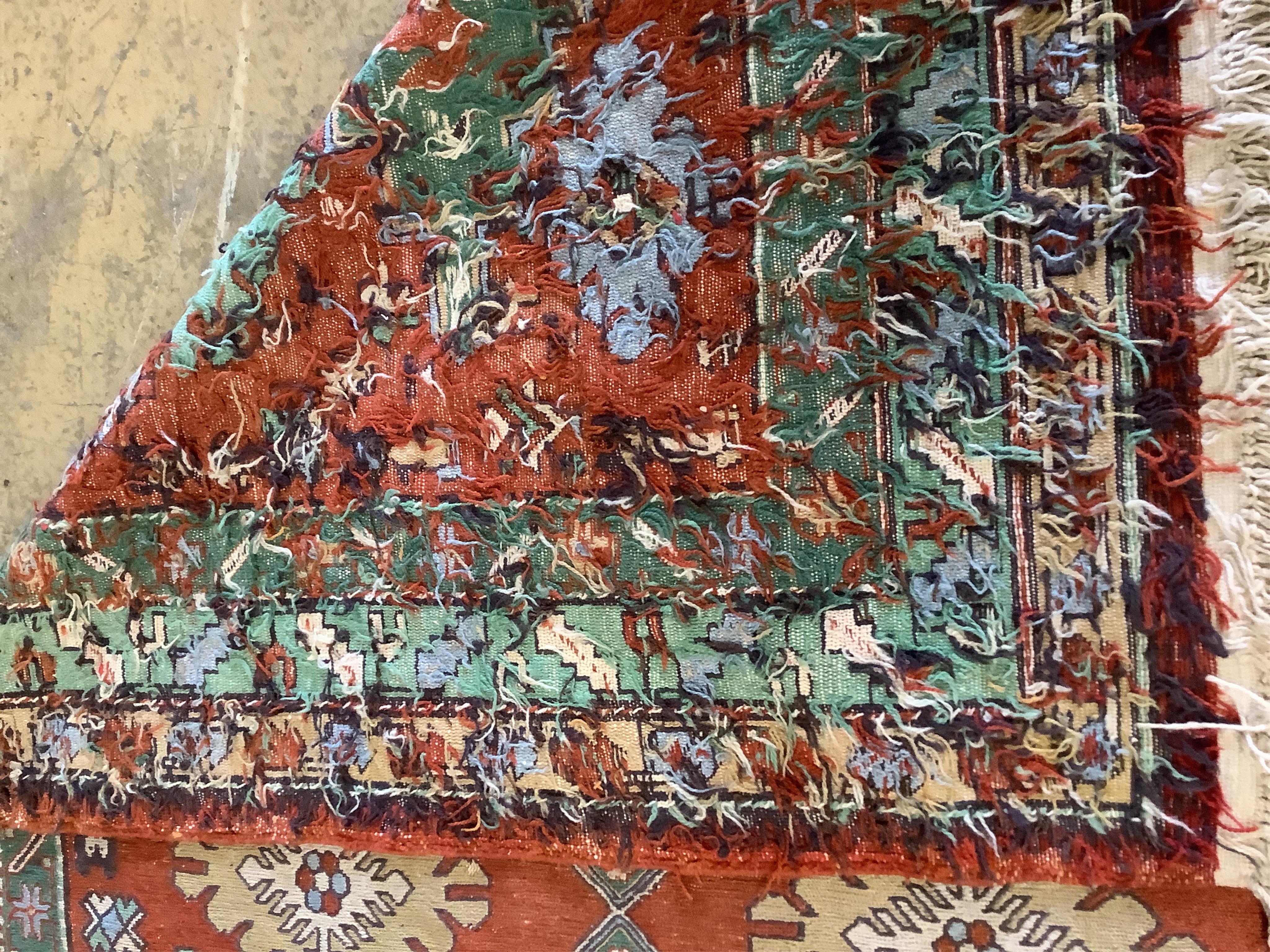 A Caucasian style polychrome red ground carpet, 244 x 160cm. Condition - fair